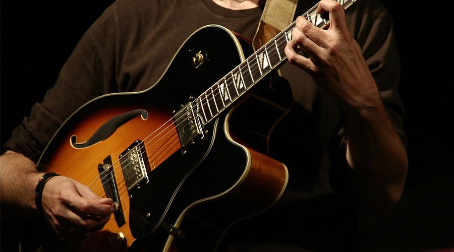 Beginner guitarist practicing 4/4 rhythm strumming
